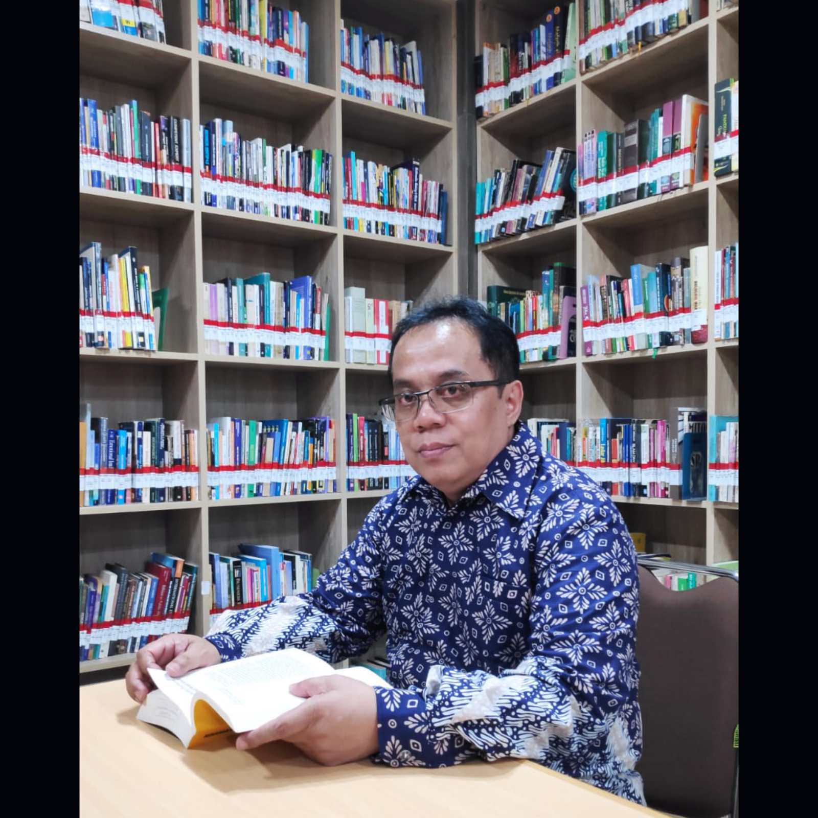 Dr. H. Benrahman membaca buku di ruang perpustakaan pada 15 Agustus 2026
