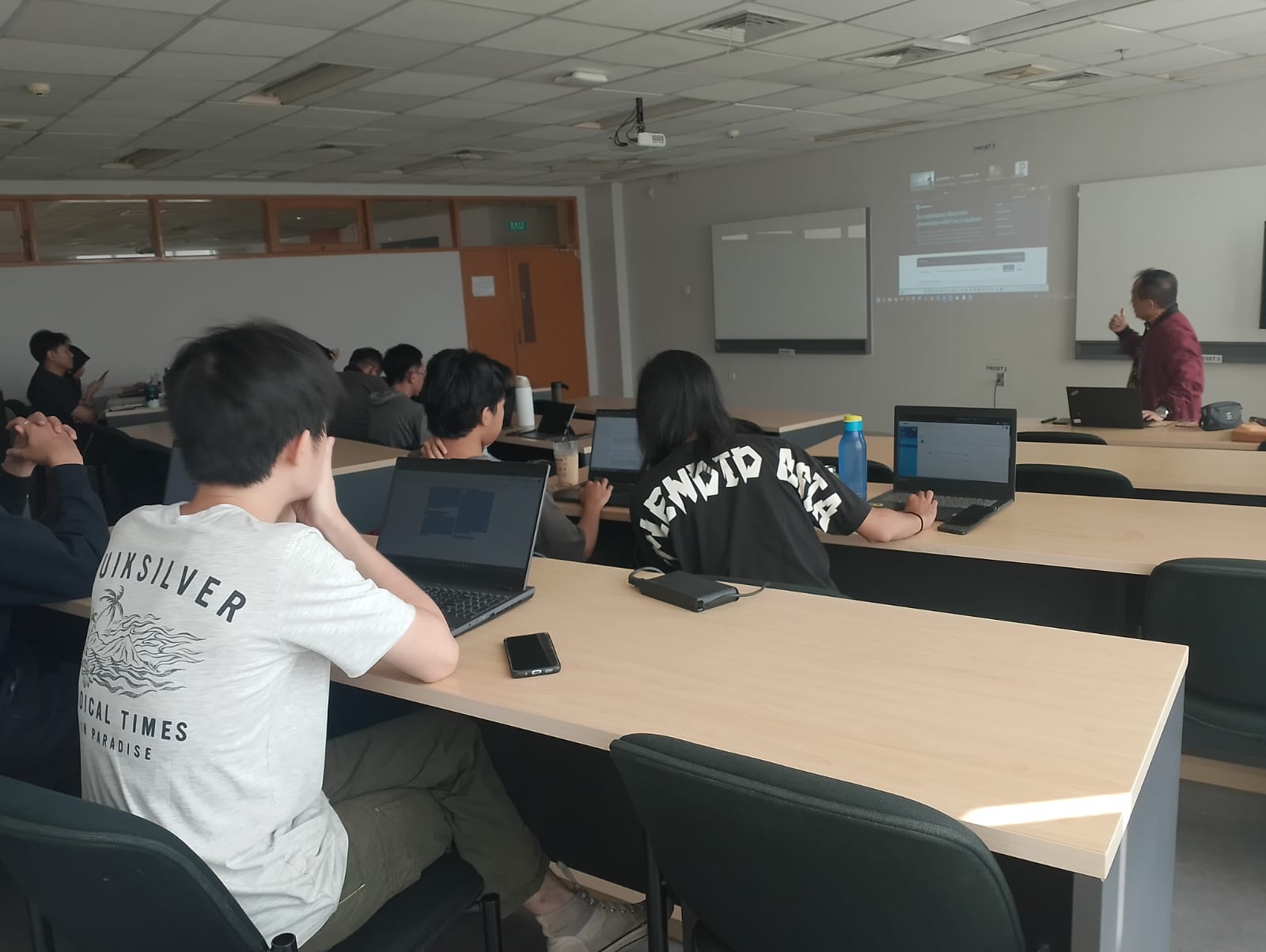 MMSI BINUS University students following the visiting lecture with digital learning devices